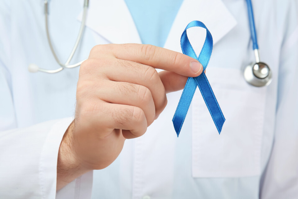 A doctor holds a blue colon cancer awareness ribbon