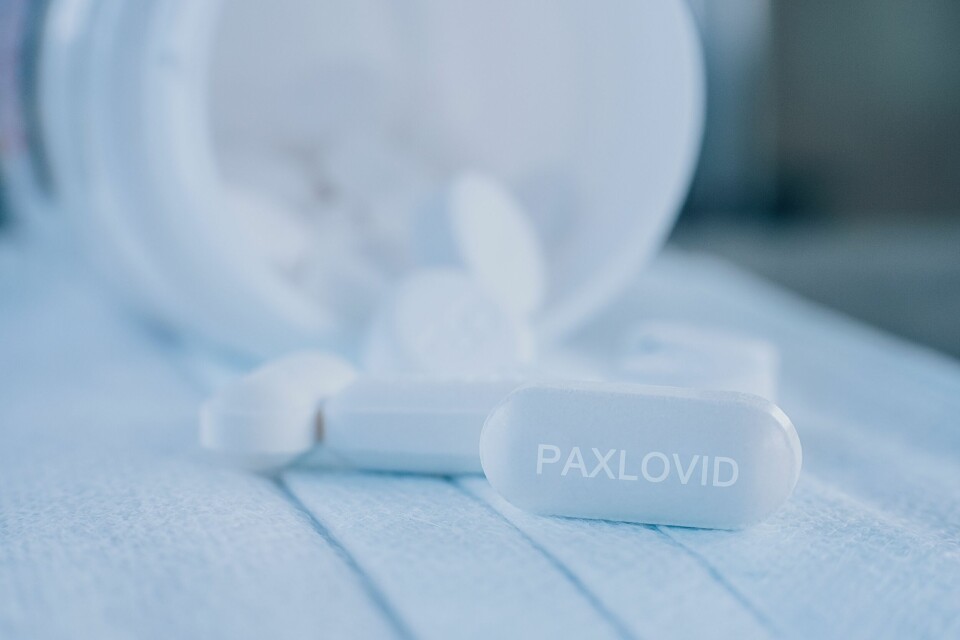 A white tablet on a table with the word Paxlovid written on it