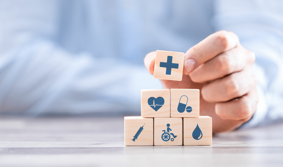 A photo of a hand arranging blocks to show insurance concept