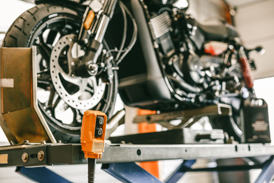 A photo of a motorbike having a check in a garage