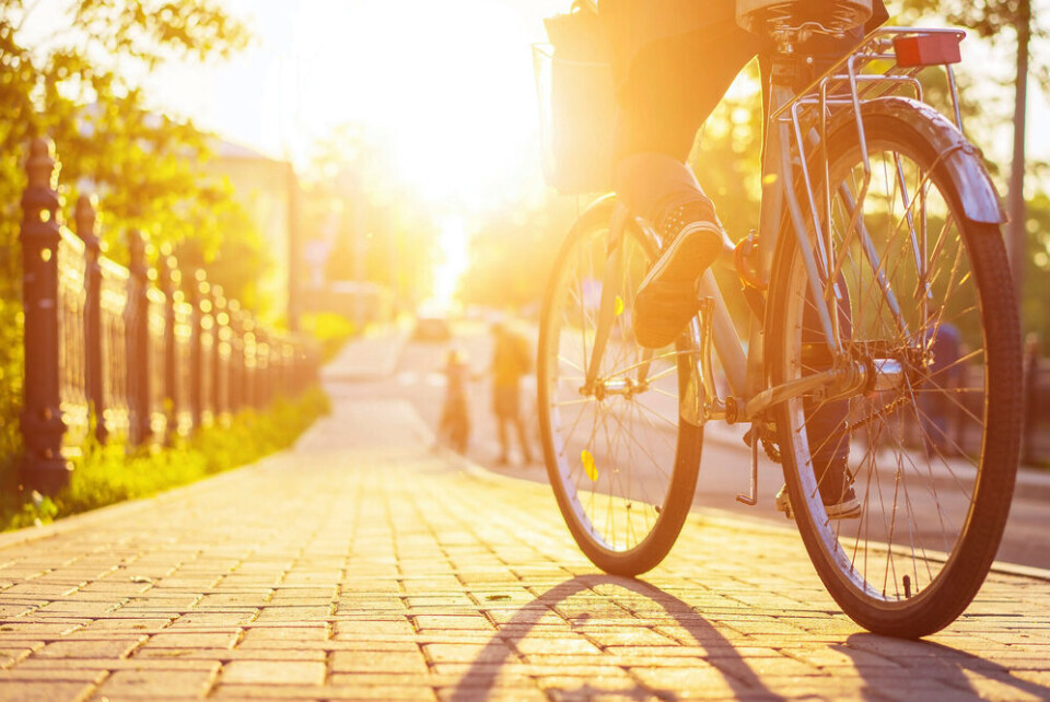 A young businesswoman cycles to work across a bridge