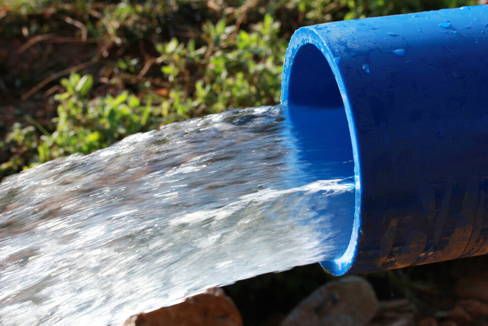 A photo of an irrigation tube with water rushing out of it