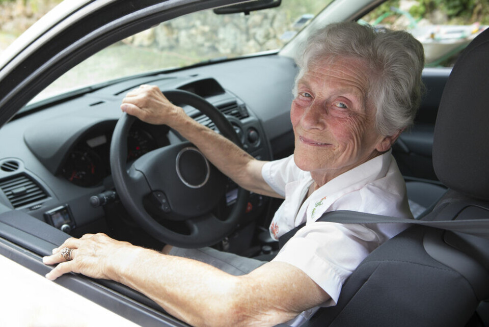 An older woman at the wheel of a car