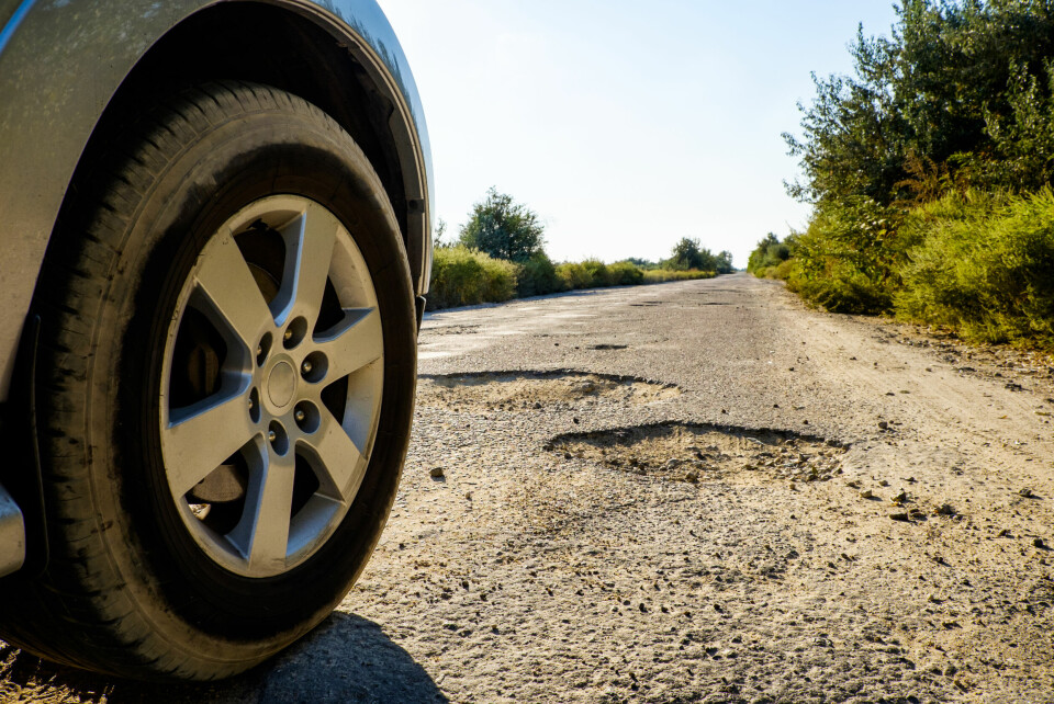 Car wheel in front of a pothole