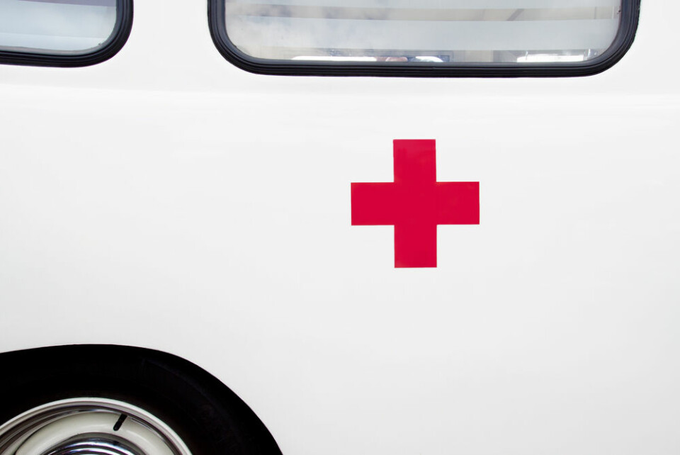 A red emergency cross sign on the side of a white bus