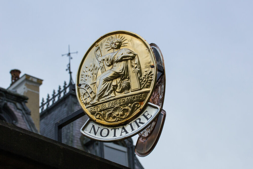 A sign on a wall reading ‘Notaires’ with an arrow