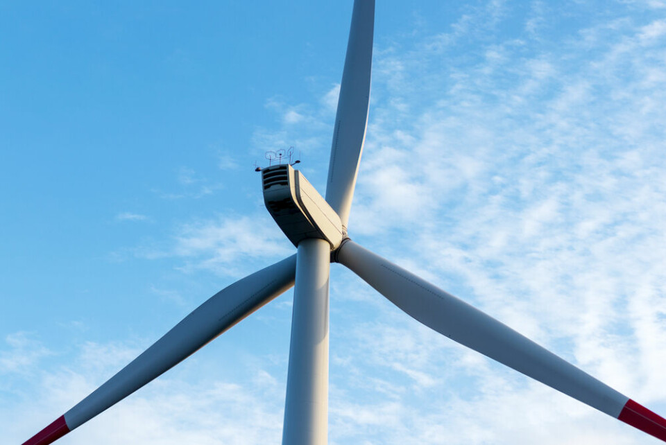 A close-up of a wind turbine with blue sky behind