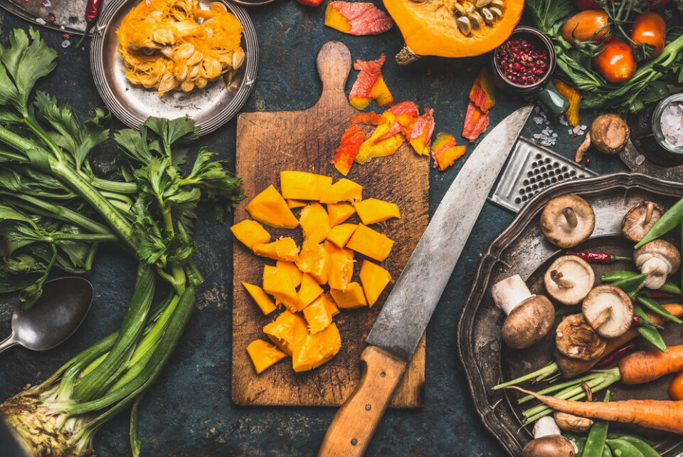 VICUSCHKA | Shutterstock Pumpkin on a chopping baord surrounded by other vegetables