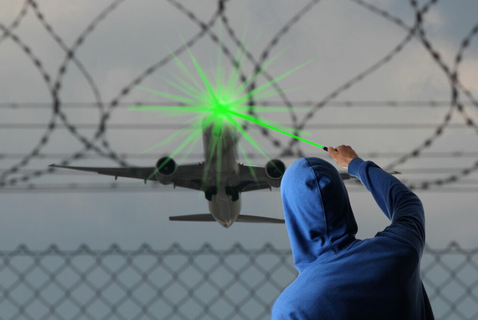 An image concept of a man shining a laser into an aircraft cockpit