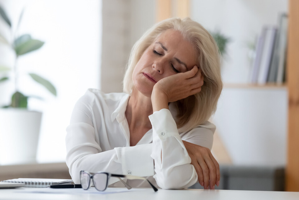 Woman falling asleep at her desk, head leaning on her hand