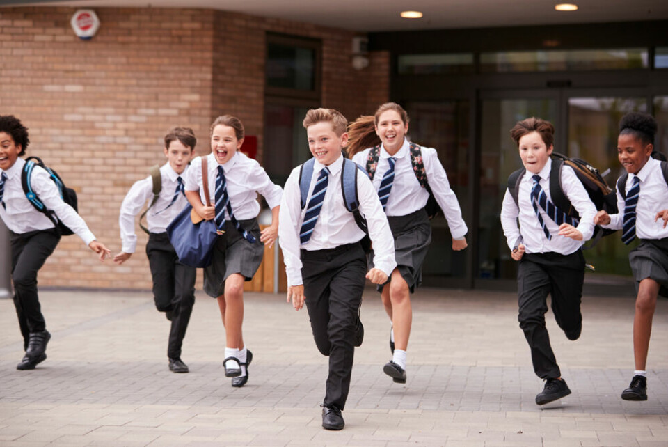 A photo of school children in uniforms running towards camera