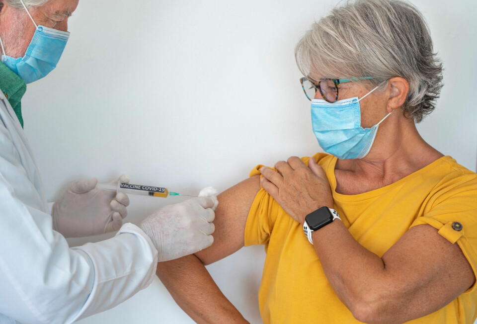 A photo of an older woman receiving a Covid vaccine