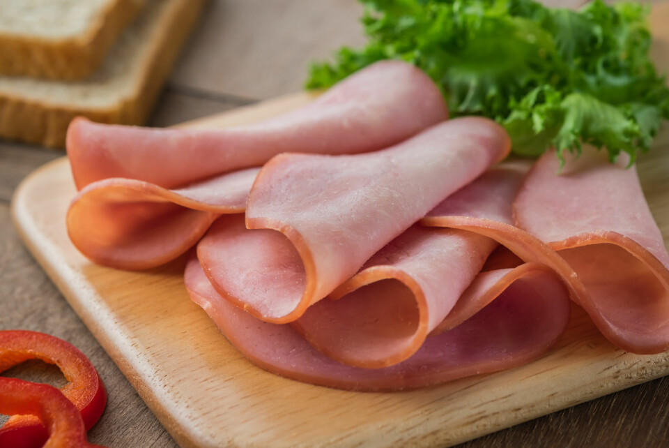 Sliced cooked ham arranged on a wooden board
