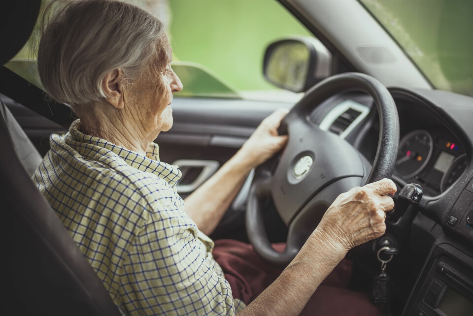 An older woman behind the wheel of a car