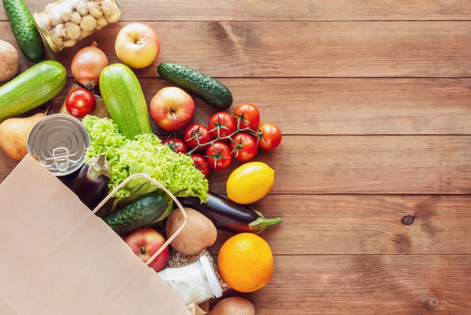 A photo of a paper shopping bag with health food spilling out