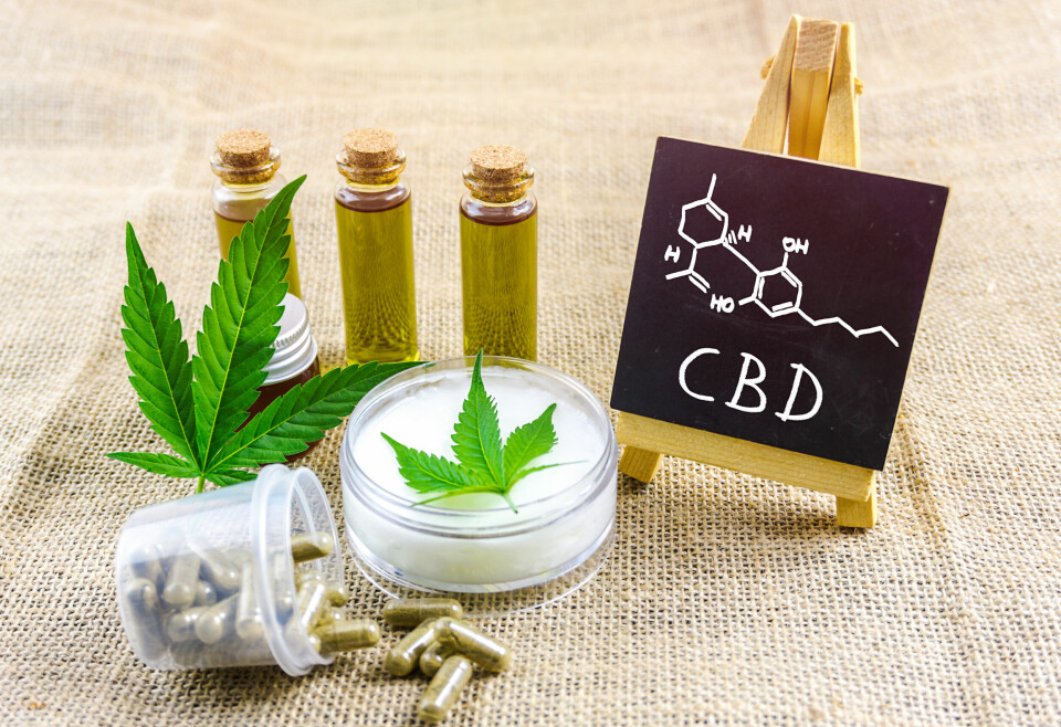 A close-up photo of CBD products with a mini blackboard showing the scientific compound