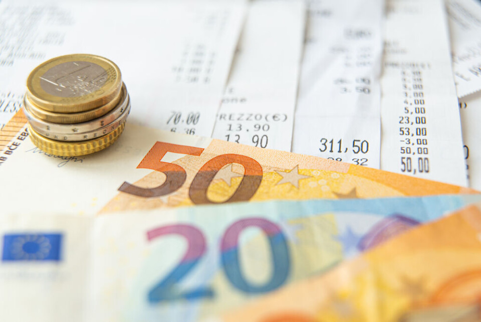 A photo of a pile of Euro coins and banknotes, and receipts