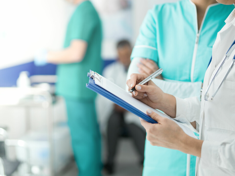 A close-up anonymous shot of hospital workers with a clipboard and wearing scrubs