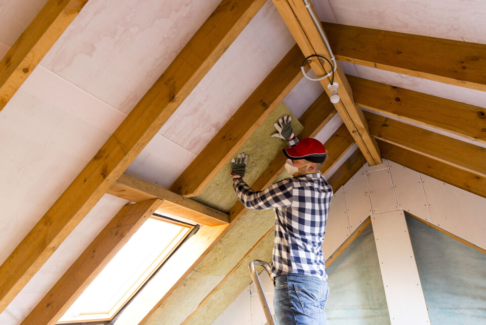 Man installing insulation in roof