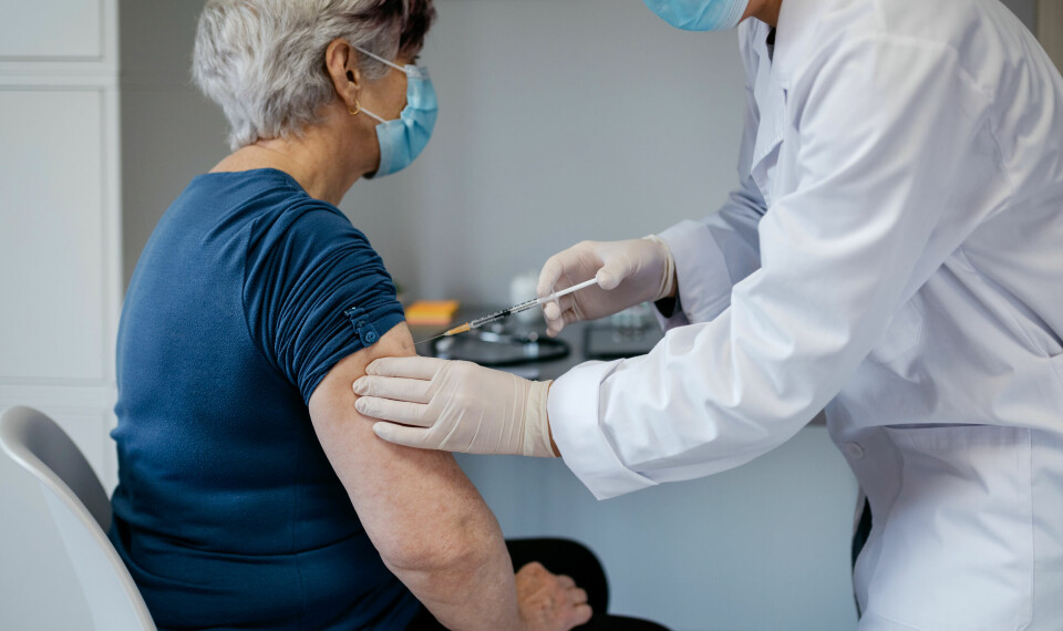 An older woman receives a Covid vaccine from a nurse