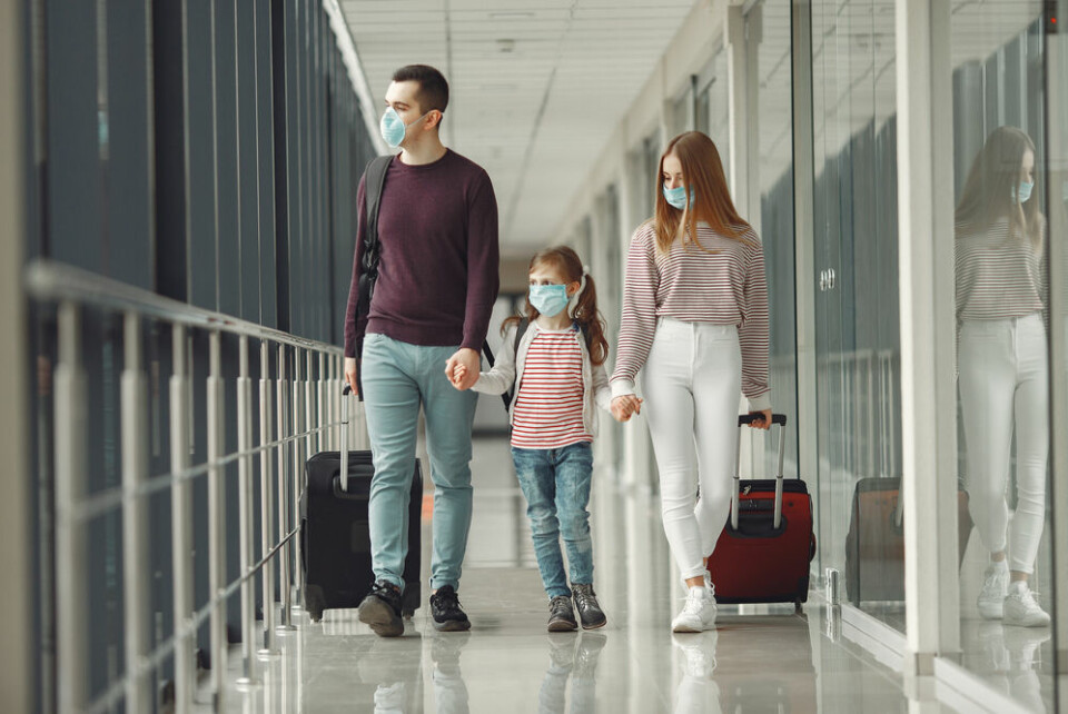A family at an airport wearing masks