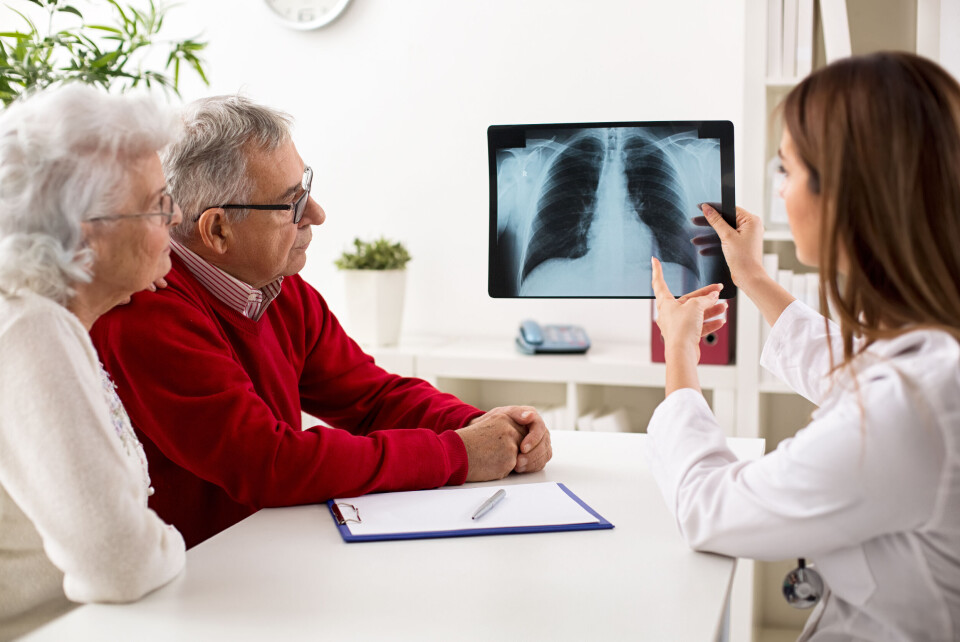 A doctor explaining an image of lungs to an elderly couple