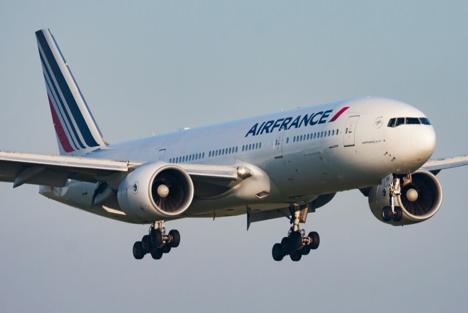 An Air France flight with its landing gear visible, preparing to land at Paris Roissy-Charles de Gaulle