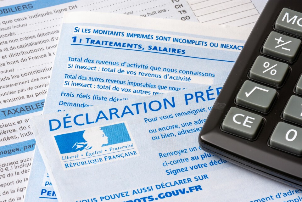 French tax forms and information on a table with a calculator