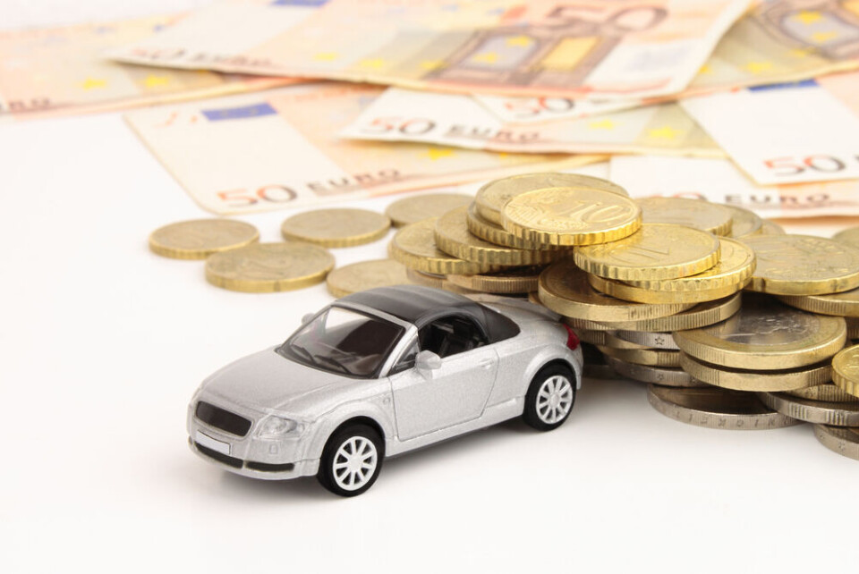 spectrumblue / Shutterstock A model car on a table next to a pile of cash and coins