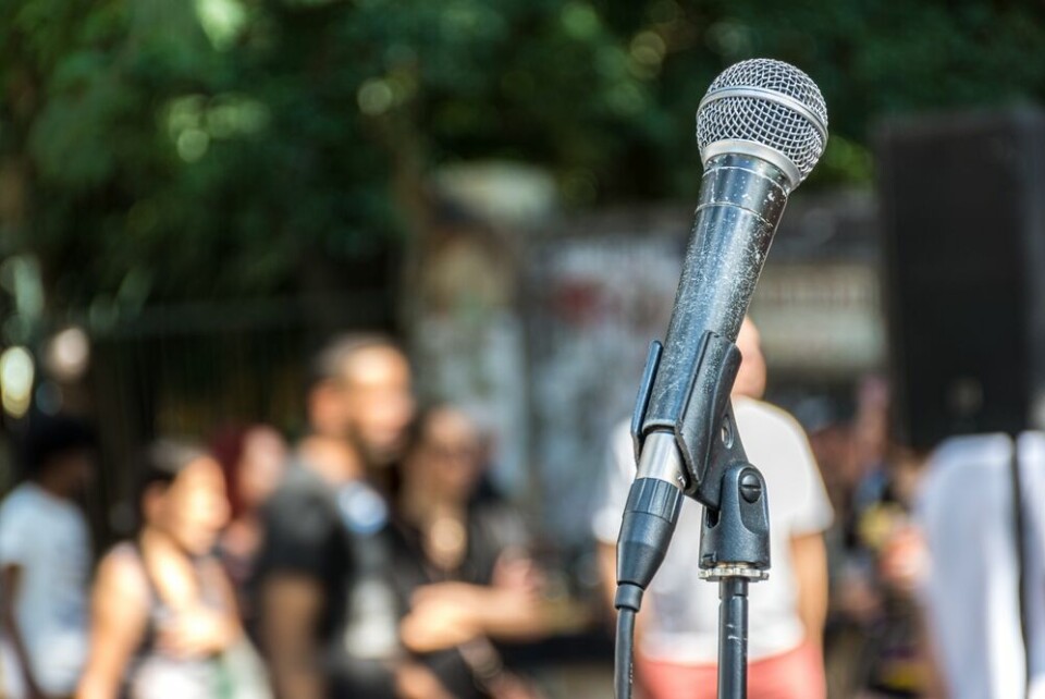 A microphone pictured against a blurred outdoor background