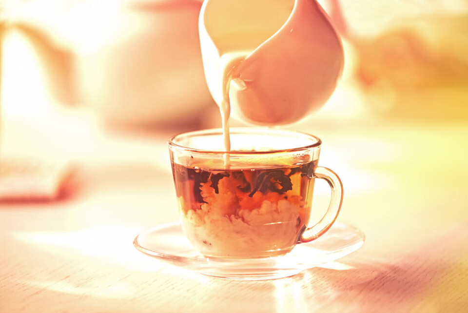 A photo of milk being poured into a hot drink