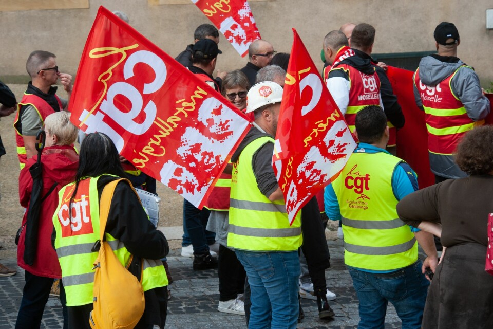 A photo of CGT union workers holding flags during a strike