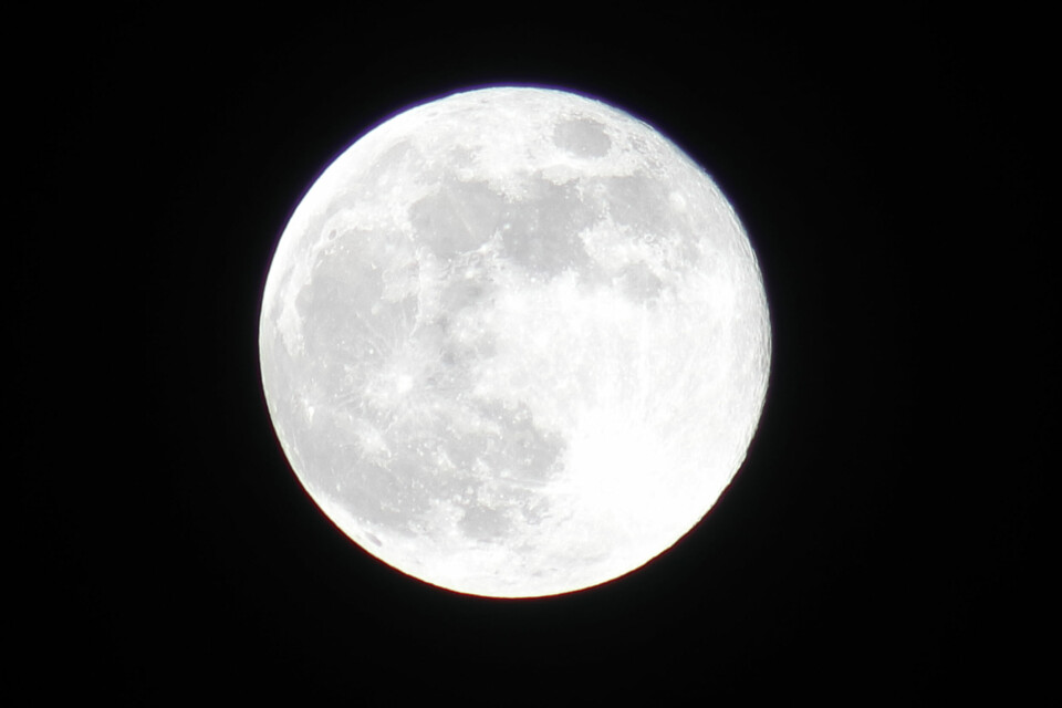 A photo of the moon bright in the sky