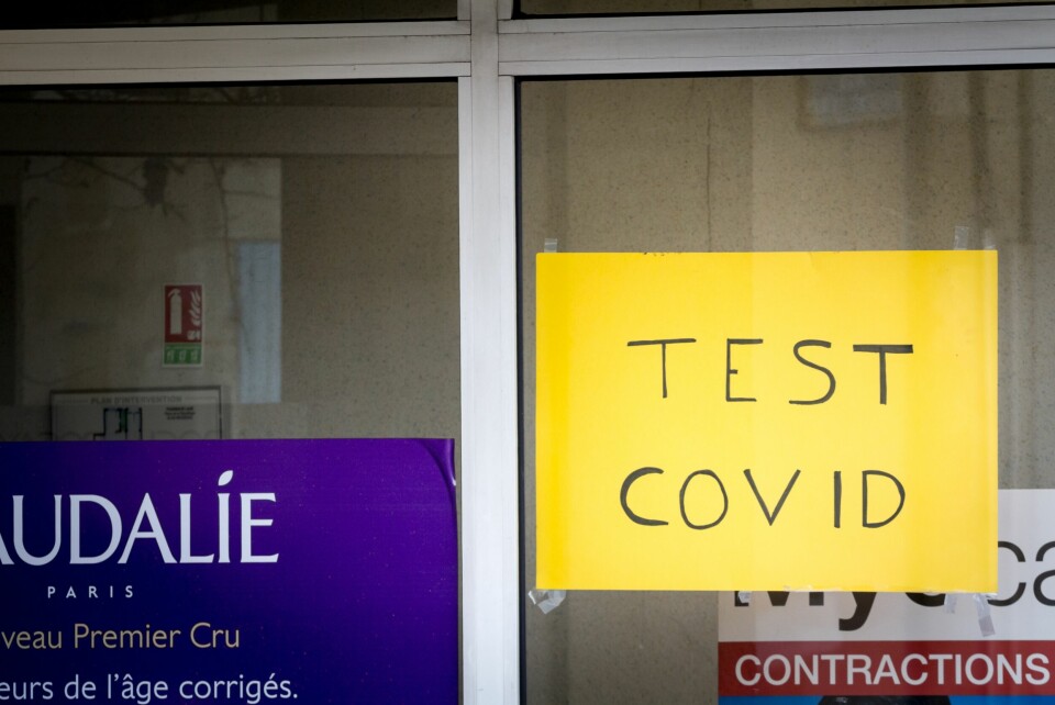 A handwritten sign in a window saying “Test Covid”