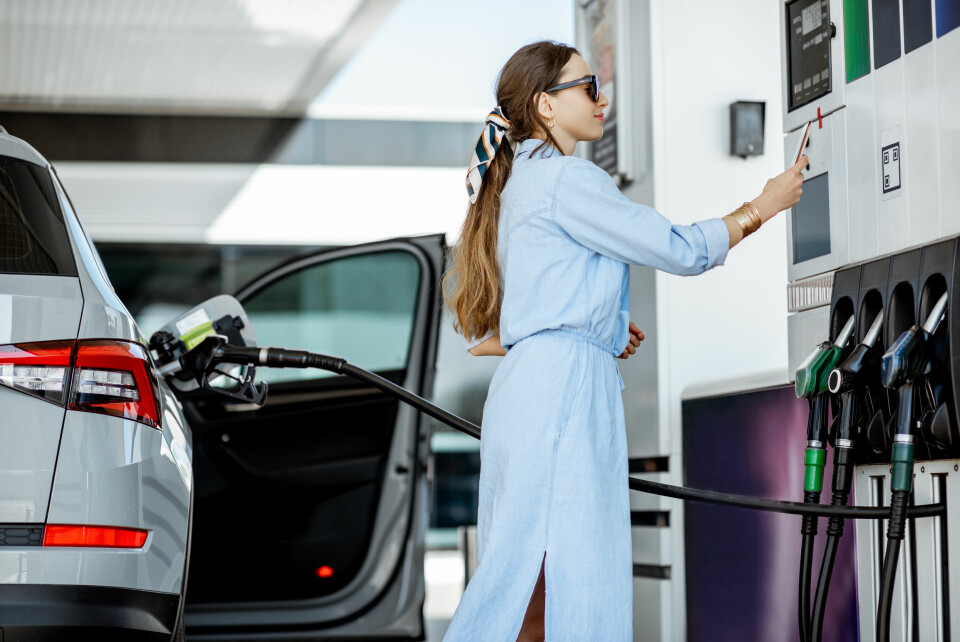A woman paying for petrol with a card at a pump