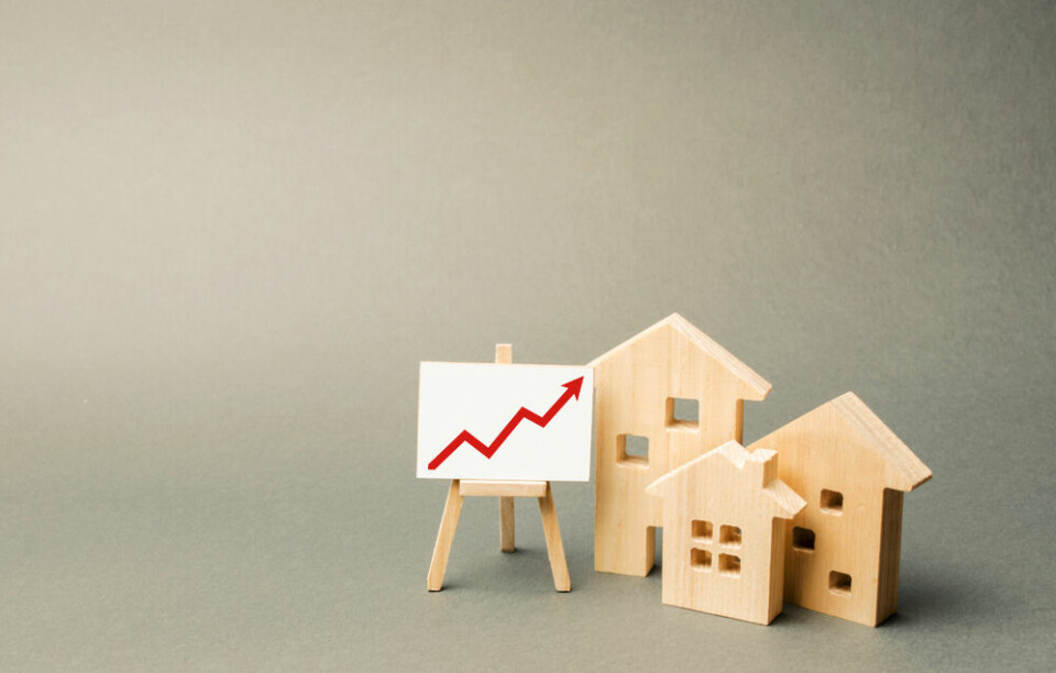 A view of three model houses and a small display board showing an arrow graph, to suggest property trends