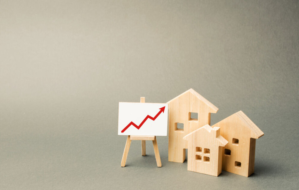 Andrii Yalanskyi | Shutterstock A view of three model houses and a small display board showing an arrow graph, to suggest property trends