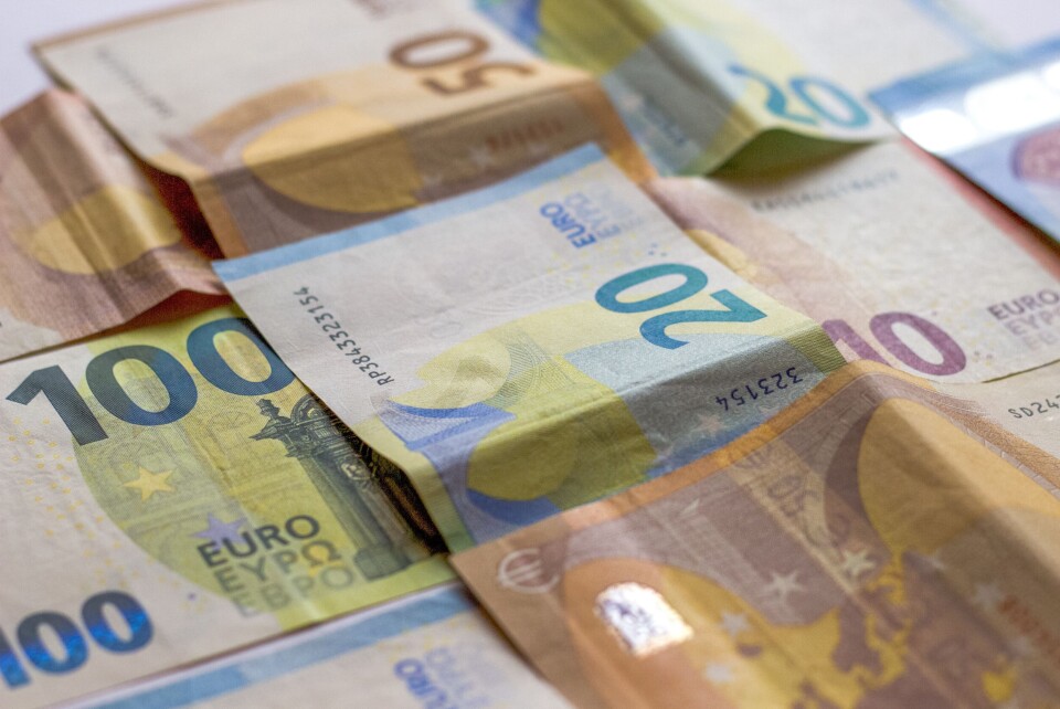 A photo of a man holding a pile of €50 banknotes