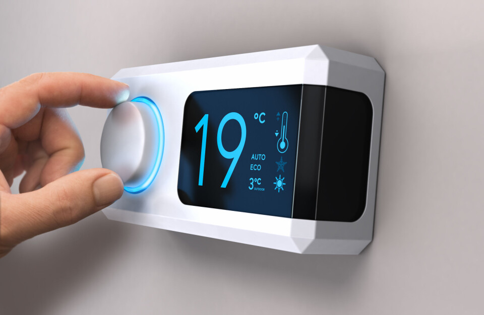 Olivier Le Moal / Shutterstock A photo of someone turning their thermostat down