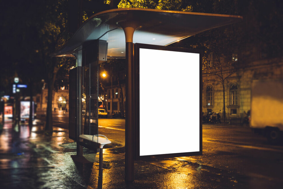 A blank, light-up advertising board on a bus stop in France