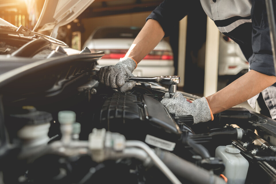 A mechanic working on a car engine in a garage