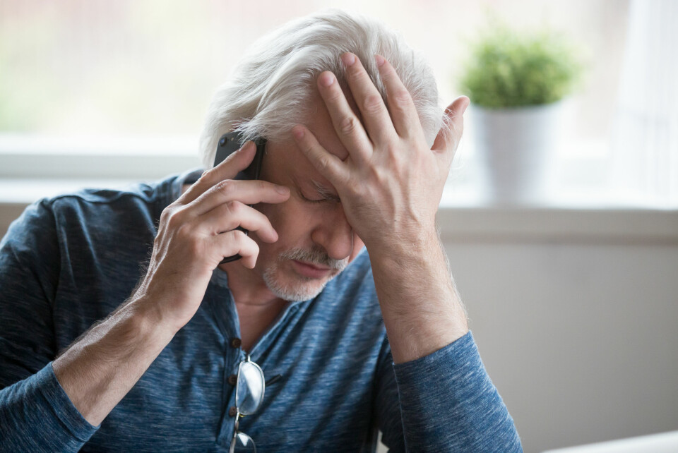 A photo of an older man frustrated while on the phone