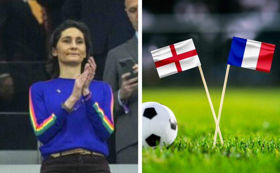 A photo of a football next to two flags, one the England flag and one the French flag, on green football pitch grass