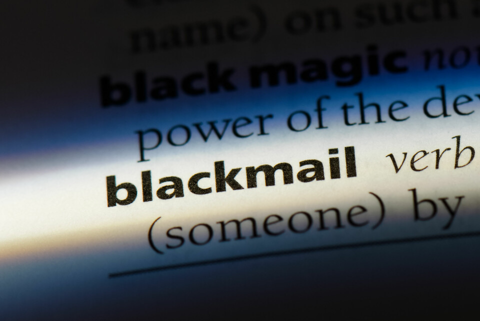 A close-up photo of a dictionary definition of the word ‘blackmail’