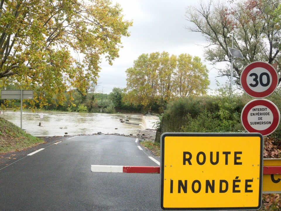 An image of a flooded road closed off with a barrier