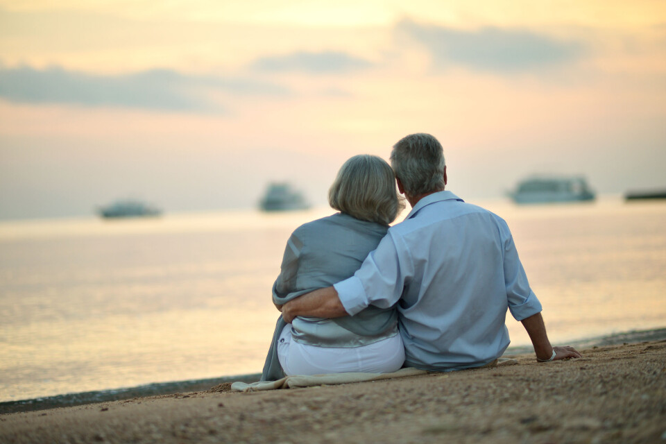 Ruslan Huzau / Shutterstock An older couple sitting together on a beach