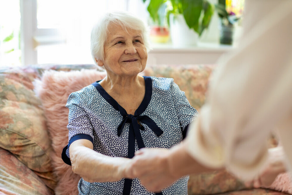 A photo of an older woman being helped up by another person