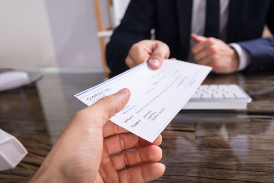 A man in a suit handing over a cheque