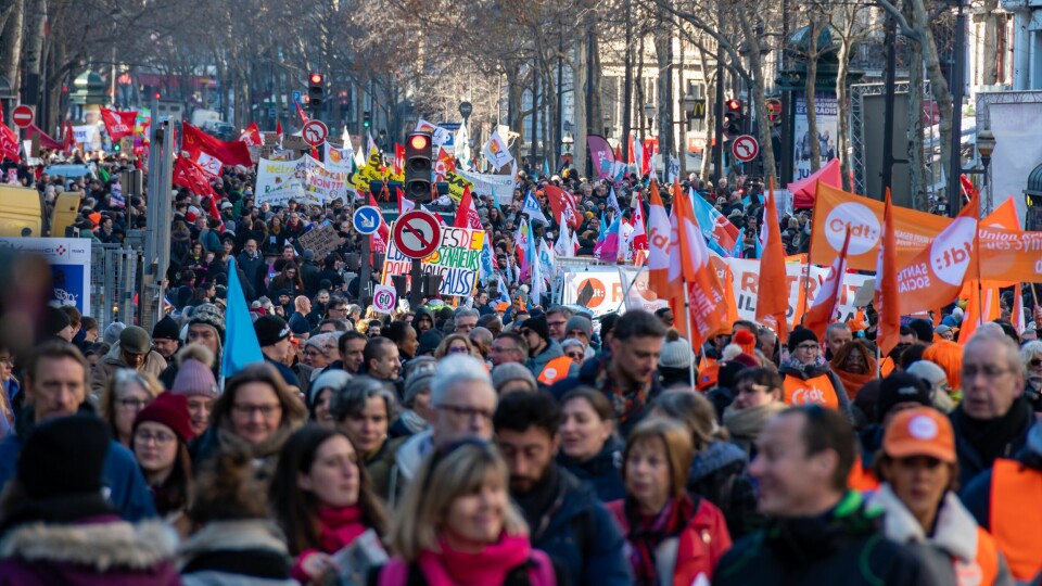A photo of protestors with banners marching against pension reform in France