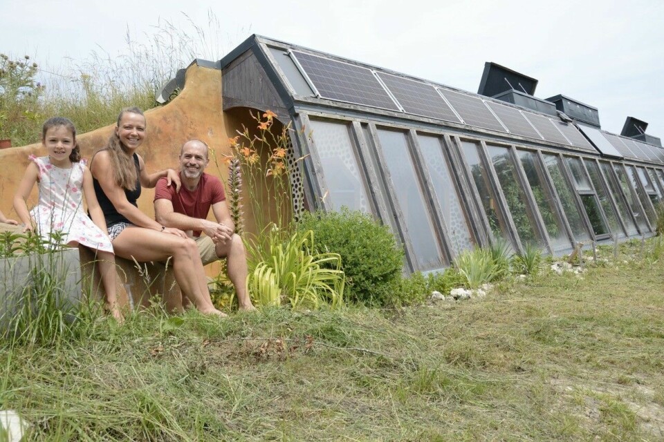 earthship eco house with family sat outside